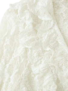 Detailed macro view of white lace fabric with mesh texture and ruffled edge design