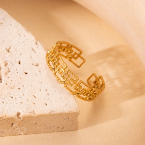 Detailed view of adjustable gold titanium ring with geometric hollow chain pattern on stone