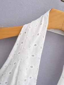 Dettaglio del vestito estivo bianco con ricami traforati e finiture in pizzo inglese