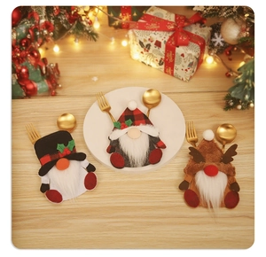 Close-up of three festive Christmas gnome cutlery holders on a warm wooden tabletop