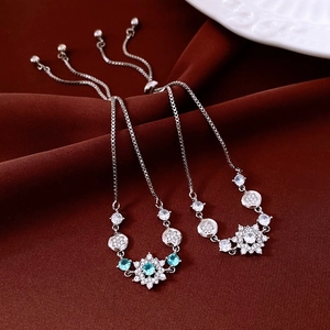 Detail of adjustable snowflake bracelets with zircon stones on a deep red fabric