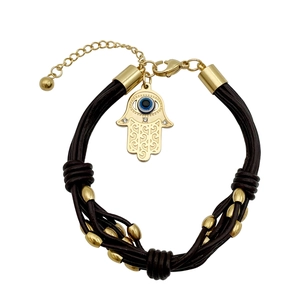 Hamsa Hand and Evil Eye leather cord bracelet with golden beads on white background
