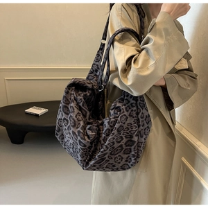Detail of soft leopard print PU shoulder bag showing textured fabric and metallic strap rings