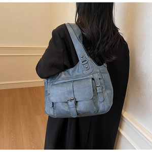 Close-up of blue PU leather shoulder bag featuring multi-pocket design and buckle strap