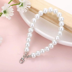 Short faux pearl chain with silver lobster clasp on a soft pink decorative background