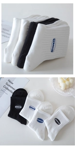 Detail showing white and black cotton sports socks with embroidered MOMOGN logo