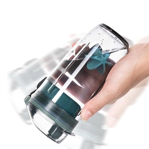 Shaker à protéines étanche avec boule de mélange étoile et couvercle vert sur fond blanc
