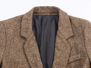 Détail d'un blazer marron à chevrons montrant les coutures du revers et la doublure noire