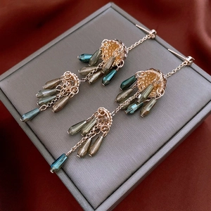 Detail of vintage gold tassel earrings with teardrop crystals on a premium velvet box