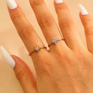 Detail of gold and silver sunburst rings with sparkling zircons on a model's hand