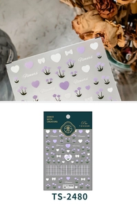 Detailed macro view of 3D relief nail art stickers with purple hearts and flowers