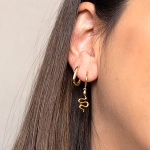 Detail of model wearing a gold snake pendant earring and square hoop earrings set