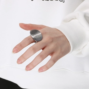 Close-up of a large oval stainless steel ring featuring a matte brushed metal texture