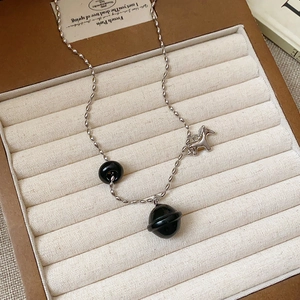 Detail of tiger eye bead necklace with silver horse pendant in a brown jewelry box