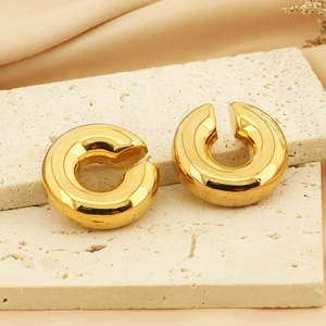 Polished 18k gold plated hollow C-shape donut ear cuffs on a natural stone base