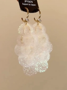 Macro shot of elegant white bubble cluster earrings with gold hooks and zircon detail