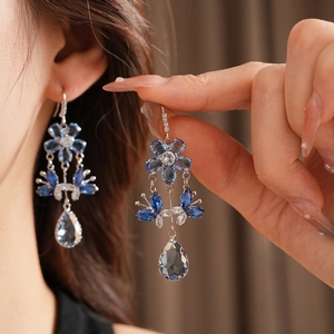 Elegant zircon flower tassel earrings with blue and white teardrop gems in silver setting