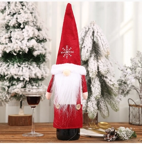 Detail of red Christmas gnome wine bottle cover with snowflake embroidery and faux fur