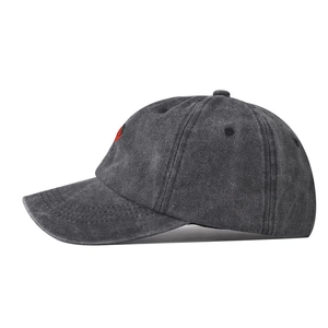 Detail view of washed dark grey cotton baseball cap with red strawberry embroidery