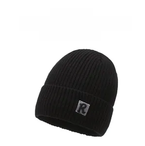 Close-up of black ribbed knit beanie with R-letter patch and thick warm texture