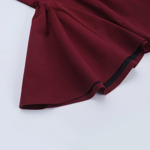 Vue détaillée d'une robe bordeaux avec poignets à volants élégants et tissu lisse