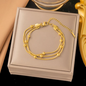 Detail of triple-layered gold stainless steel beaded snake chain bracelet with clasp
