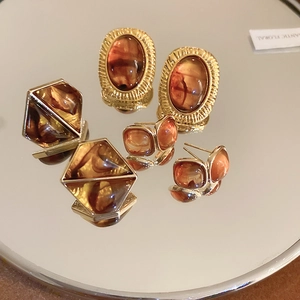 Detailed macro view of vintage amber resin geometric earrings with gold metal plating