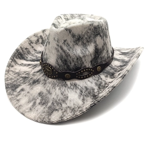 Detail of vintage cowboy hat with bull head emblem and bronze studs on leather band