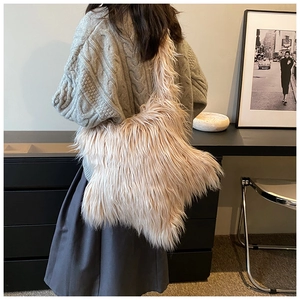 Detail of soft beige faux fur shoulder bag worn with a casual autumn outfit