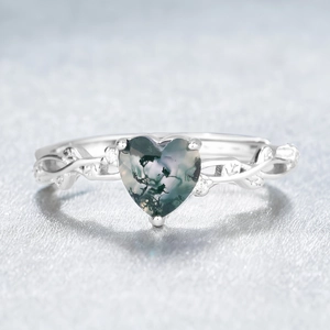 Macro detail of heart-shaped moss agate ring with vine design and small diamonds