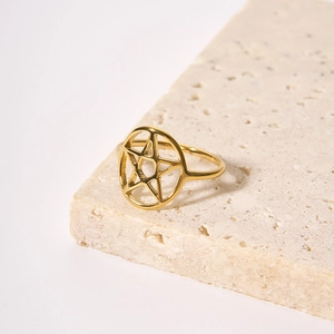 Polierter goldener Sternring auf Naturstein, minimalistischer Edelstahlschmuck