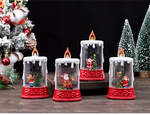 Detail of four Christmas LED glitter candles featuring Santa Claus and Xmas tree figures