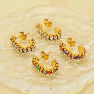 Gold U-shaped hoop earrings with clear and multicolor rhinestones on glass tray