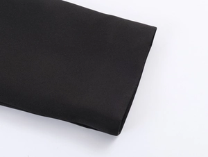 Detailed macro shot of high-quality black fabric texture with neat pleated edge finishes