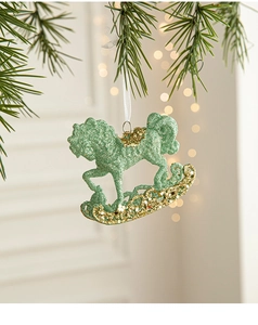 Green and gold glitter rocking horse hanging ornament on a Christmas tree branch