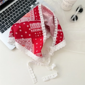 Detail of red floral cotton bandana featuring white lace trim and paisley pattern