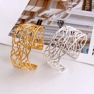 Detail view of gold and silver open bangles with irregular hollow bird nest design