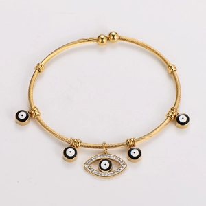 Close-up of 18K gold-plated evil eye cuff bracelet with rhinestone palm and eye charms