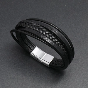 Detail of multi-layer black braided leather bracelet with silver magnetic metal clasp