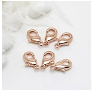 Detailed view of six rose gold lobster clasps for jewelry making on white background