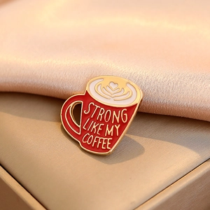 Cartoon coffee cup enamel pin with Strong Like My Coffee text on silk background