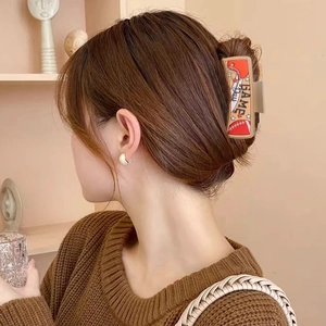 Detail of PU hair claw clip featuring football patterns and sports motifs in hair