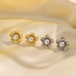 Vintage Blumen-Ohrstecker mit Perlen in Gold und Silber auf seidigem Stoff