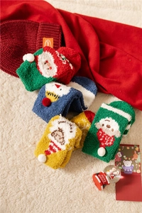 Detailed close-up of fluffy Christmas socks with festive patterns on beige fleece