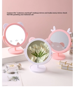Close-up of cat-ear desktop vanity mirror with rotatable frame and storage base