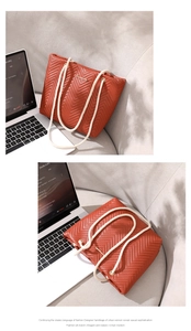Detail view of brick red chevron quilted tote bag with cream braided rope strap
