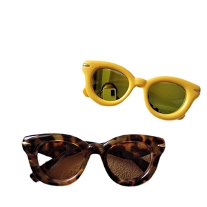 Thick frame round sunglasses in yellow and tortoise shell colors on white background