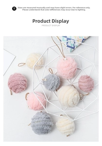 Close-up of colorful felt pom-pom ornaments with pearls and jute loops in a basket