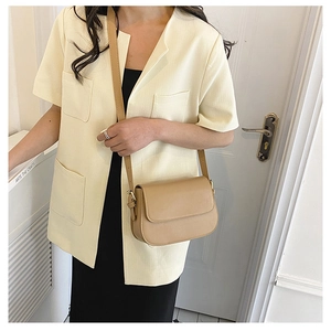 Fashionable khaki leather crossbody bag shown on a model with minimalist summer outfit