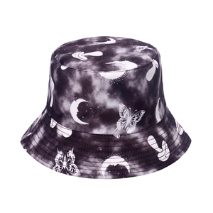 Detail of tie-dye bucket hat featuring butterfly, mushroom, and moon patterns on twill fabric